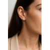 Femme portant une boucle d'oreille clou en or jaune 18 carats sertie d’un oxyde de zirconium rond