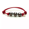 Bracelet Gambier en coton ciré rouge avec trois perles de culture de Tahiti rondes montées sur anneaux en argent.