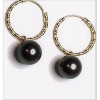 Vue rapprochée des boucles d’oreilles créoles Joyce en or 18 carats et perles de Tahiti rondes.