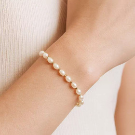 Anaïs bracelet worn on a woman’s wrist – white freshwater pearls and 18K yellow gold spacer beads