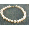 Bracelet Aurore en perles d’eau douce blanches rondes présenté sur fond marbré gris foncé