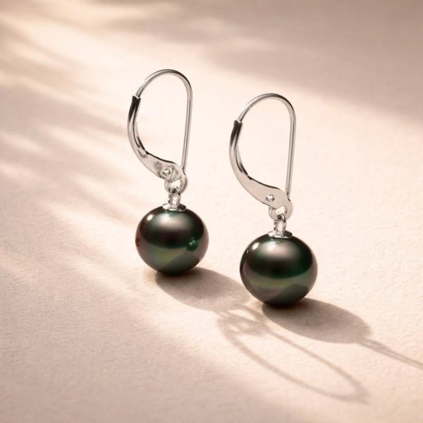 Sterling silver 925 leverback earrings with round Tahitian pearls resting on light surface, natural daylight