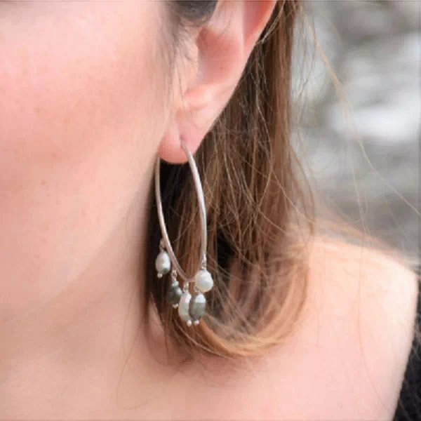 Créoles Pia en argent 925 rhodié portées à l’oreille, ornées de cinq perles keshi de Tahiti aux reflets gris et blancs